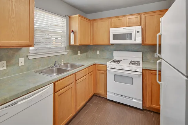 a kitchen with granite countertop white cabinets and white appliances