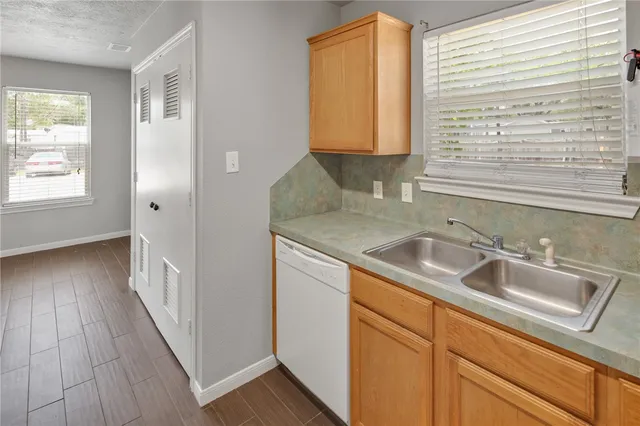 a view of a kitchen sink a window and wooden floor
