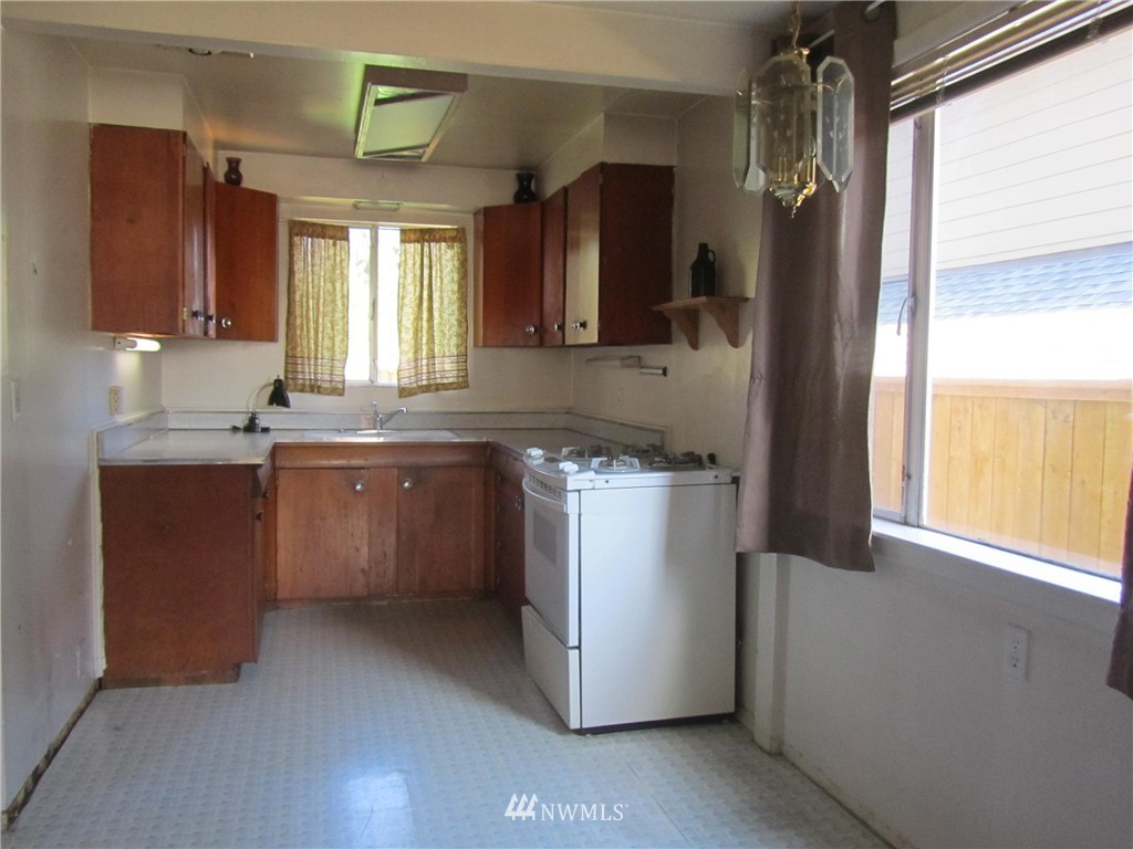 619 Ramsdell Street Fircrest, WA 98466 - Photo 6 of 12 a kitchen with a sink stove and refrigerator