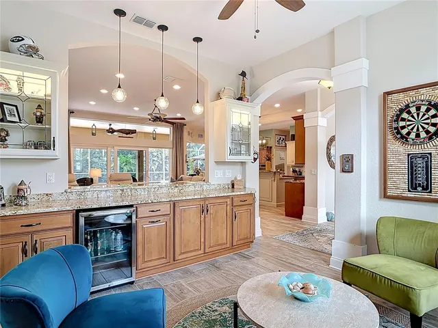 a open kitchen with stainless steel appliances granite countertop a refrigerator a sink dishwasher a dining table and chairs with wooden floor