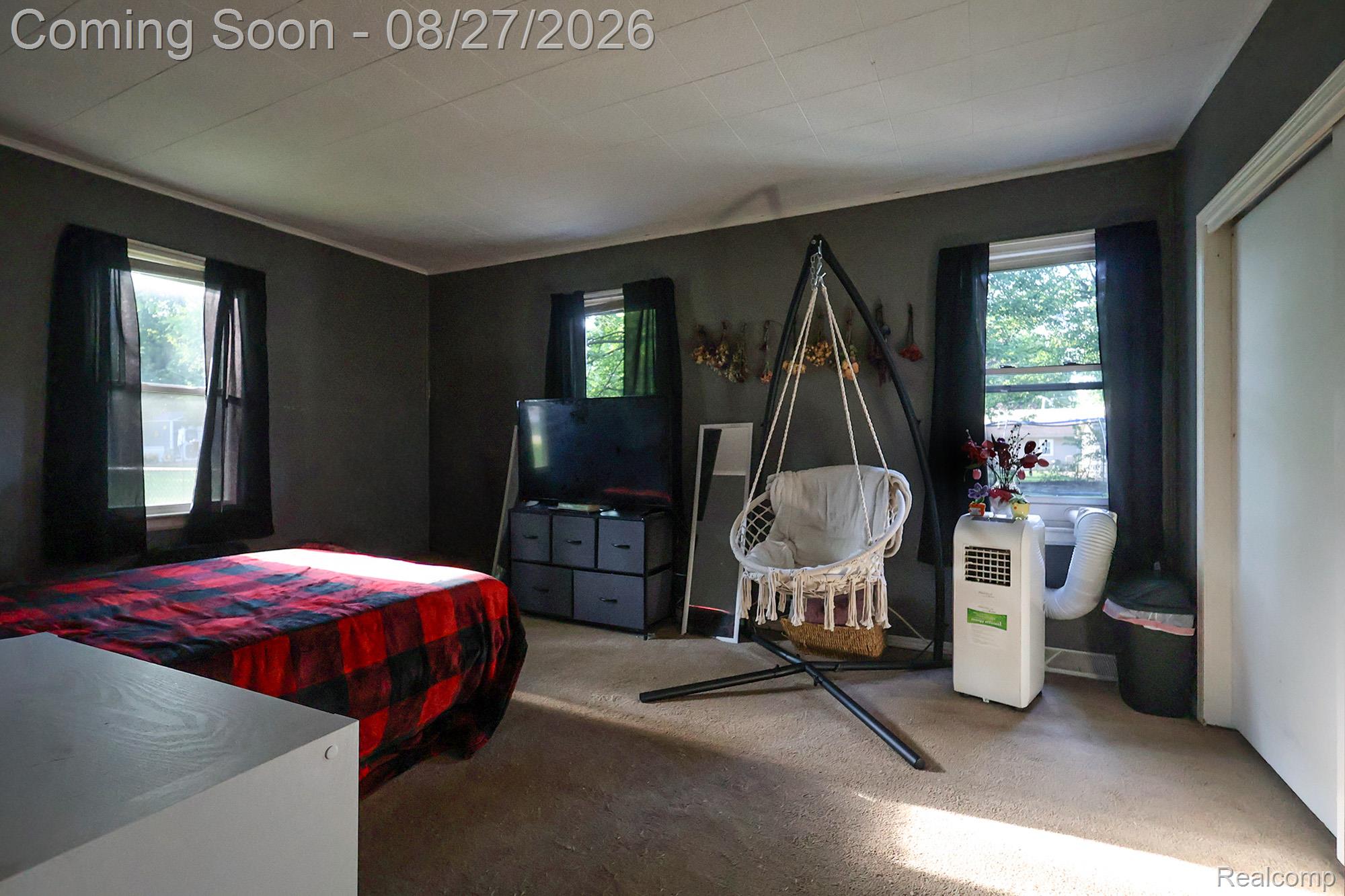 Carpeted flooring, multiple windows, and a built-in closet with bi-fold doors