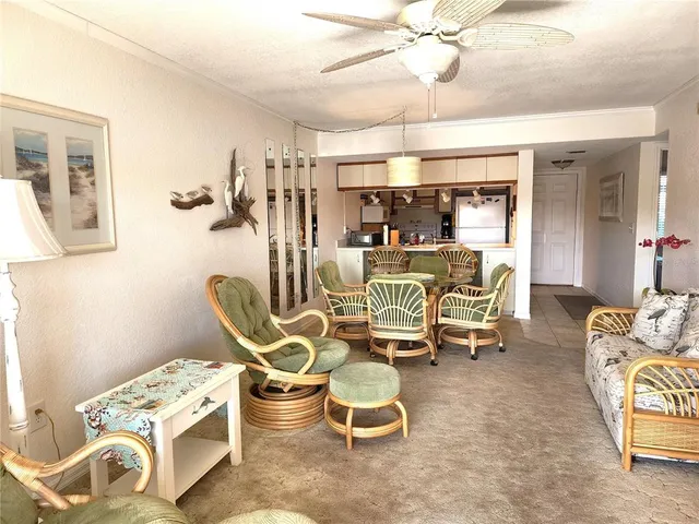 a living room with furniture a chandelier and a dining table