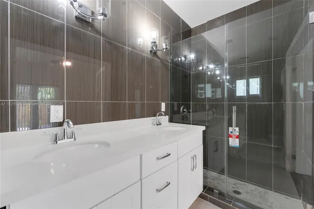 a bathroom with a sink shower and a mirror