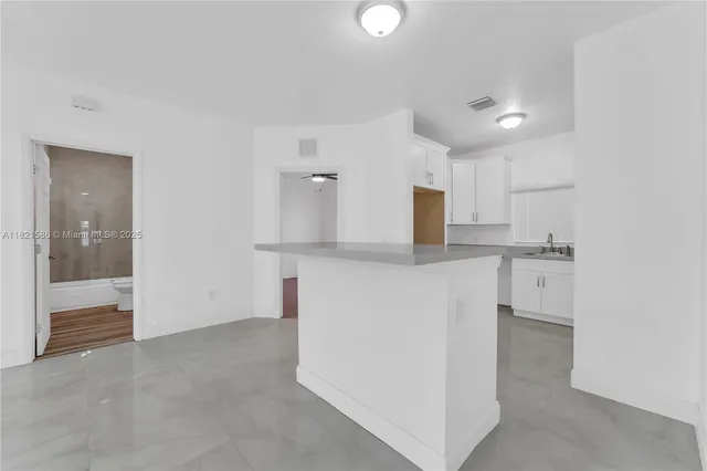 a view of a kitchen with white cabinets