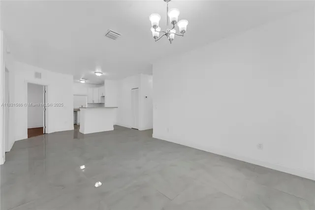 a view of a kitchen with a sink dishwasher a refrigerator and a chandelier