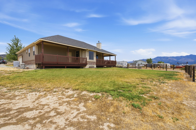 2567 West Rim Rock Drive Stockton, UT 84071 - Photo 48 of 64 Ranch-style residence featuring a covered deck, perimeter fencing, and a mountain backdrop