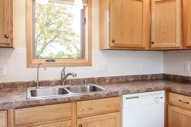4585 South Chana Road Chana, IL 61015 - Photo 13 of 76 a kitchen with granite countertop white cabinets and a sink
