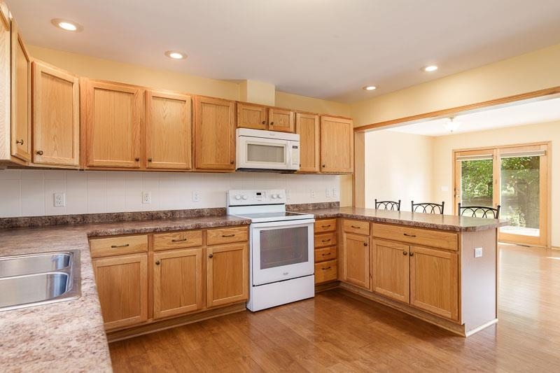 4585 South Chana Road Chana, IL 61015 - Photo 15 of 76 a kitchen with stainless steel appliances granite countertop a stove a sink and a microwave