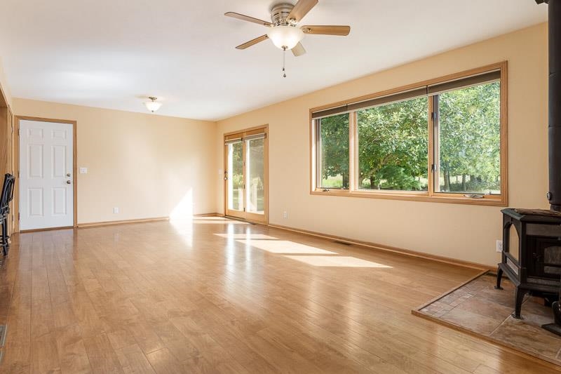 4585 South Chana Road Chana, IL 61015 - Photo 5 of 76 a view of an empty room with a window and wooden floor