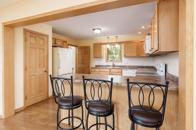 4585 South Chana Road Chana, IL 61015 - Photo 10 of 76 a kitchen with stainless steel appliances granite countertop a table chairs sink and cabinets