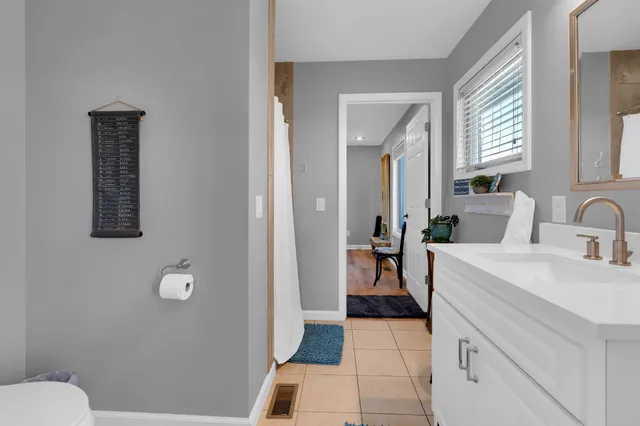 a spacious bathroom with a sink a toilet and a mirror