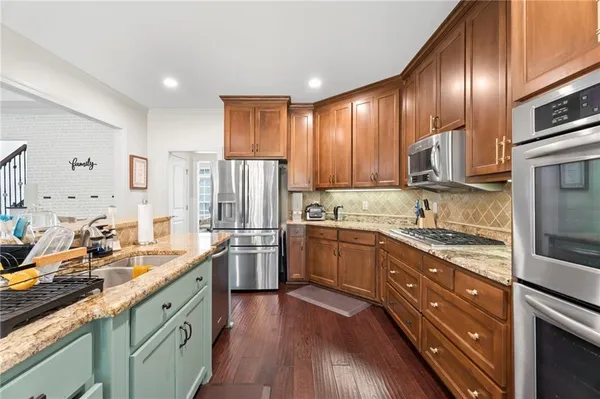 a kitchen with stainless steel appliances granite countertop a sink stove and refrigerator