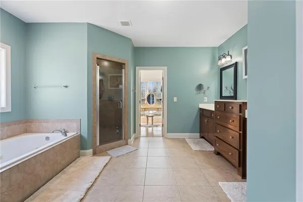 a bathroom with a bathtub sink and mirror