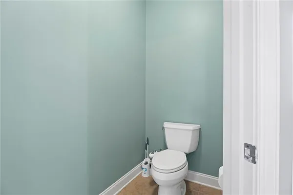 a white toilet sitting next to a small white wall