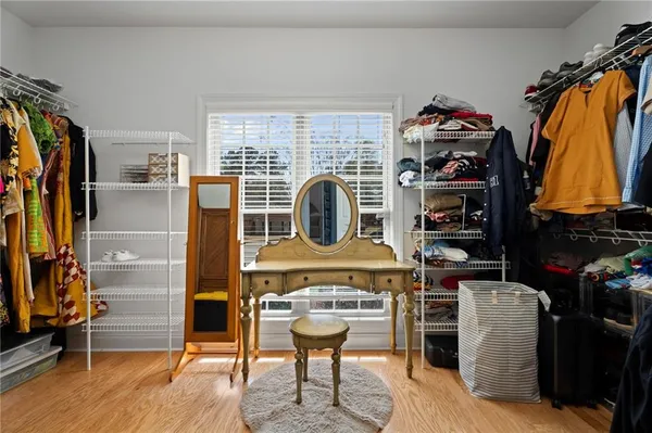 a view of a walk in closet with clothes and shoes