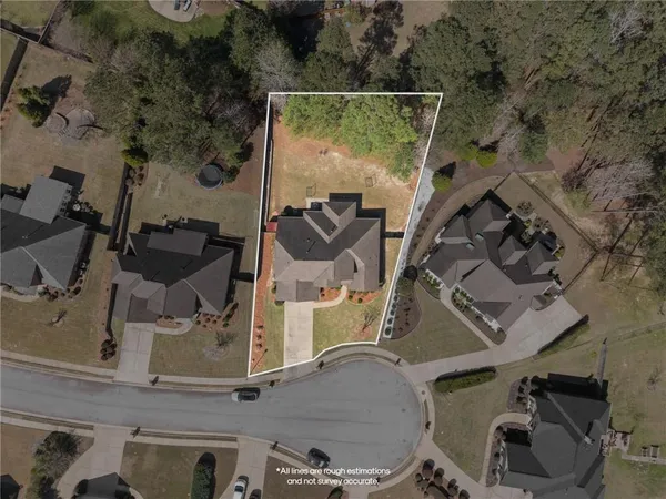 an aerial view of a house with swimming pool and wooden fence