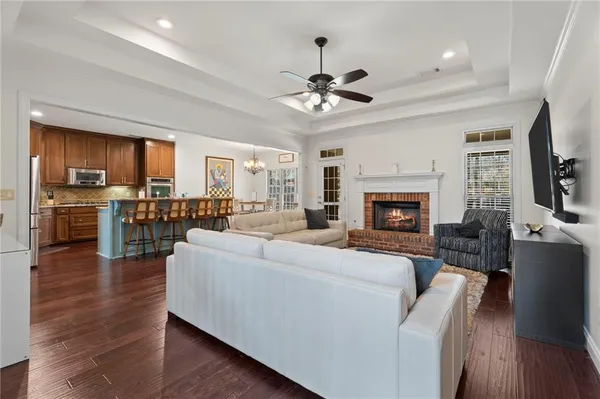 a living room with furniture a fireplace and a kitchen view