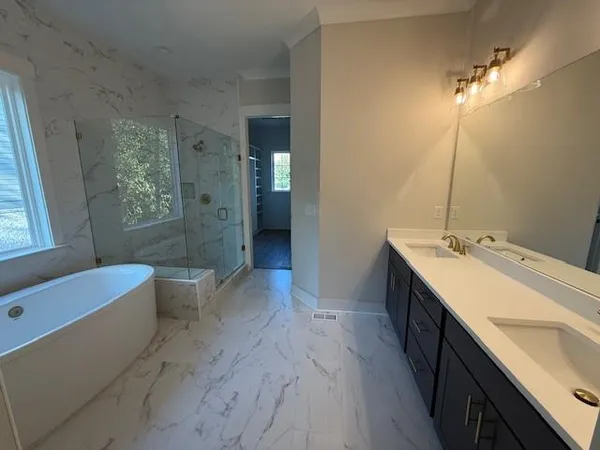 a view of bathroom with a tub sink and mirror