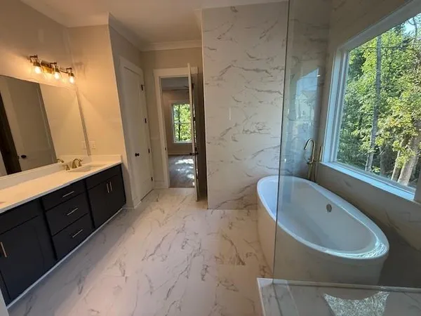 a spacious bathroom with a double vanity sink toilet mirror and bathtub