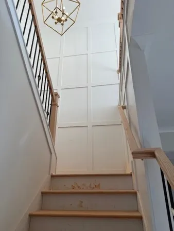 a view of staircase with white walls and railing
