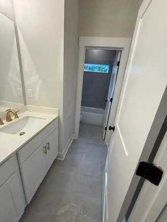 a bathroom with a double vanity sink and mirror with toilet