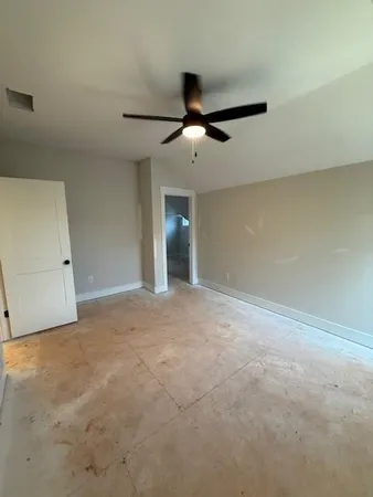 an empty room with a ceiling fan and a window