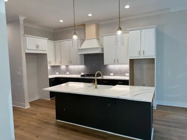 a kitchen with kitchen island sink and refrigerator