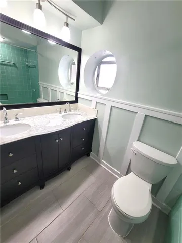 a bathroom with a toilet sink and mirror
