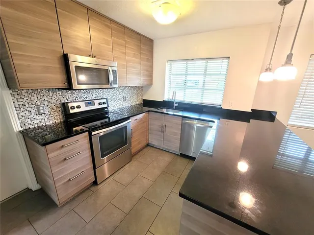 a kitchen with stainless steel appliances granite countertop a stove a sink and a microwave