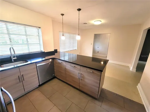 a kitchen with granite countertop a sink and a wooden floor