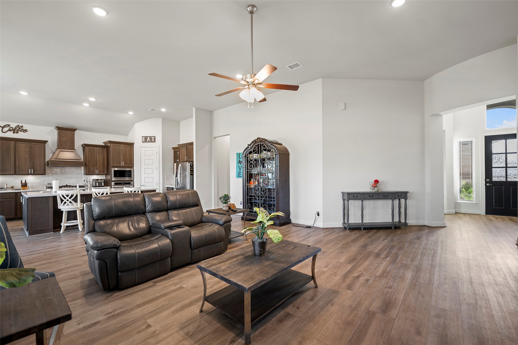a living room with furniture kitchen view and a chandelier