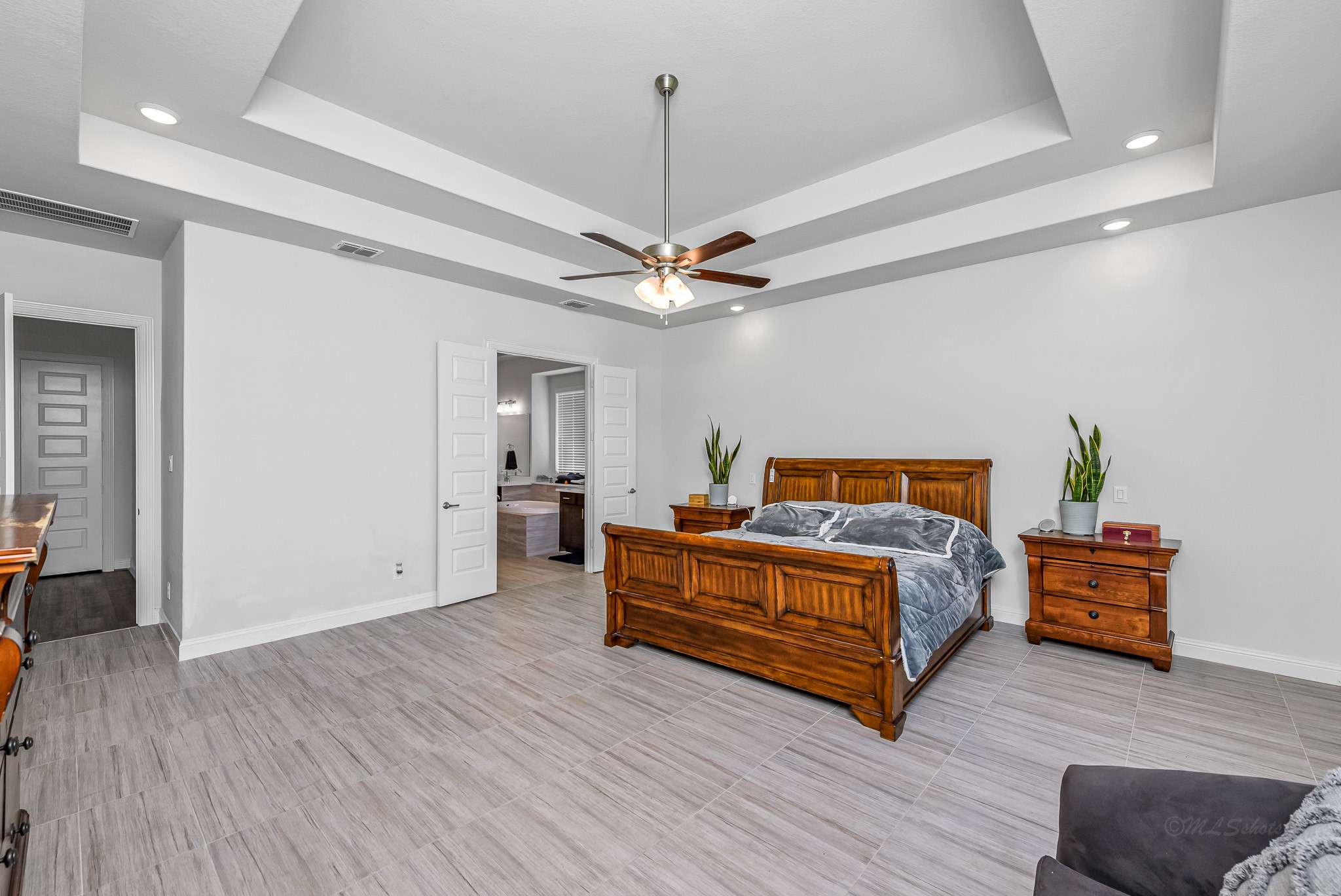 41015 Kimber Lane Magnolia, TX 77354 - Photo 3 of 44 a spacious bedroom with a bed and a chandelier