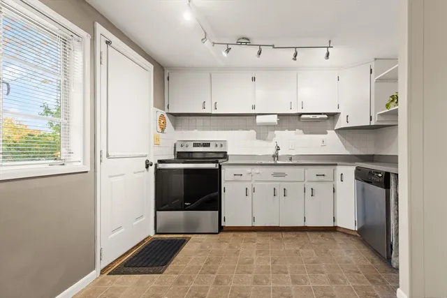 a kitchen with a stove sink and cabinets
