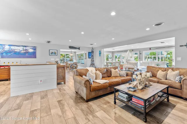 a dining room with furniture a chandelier and wooden floor