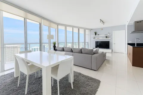 a living room with fireplace furniture and a large window