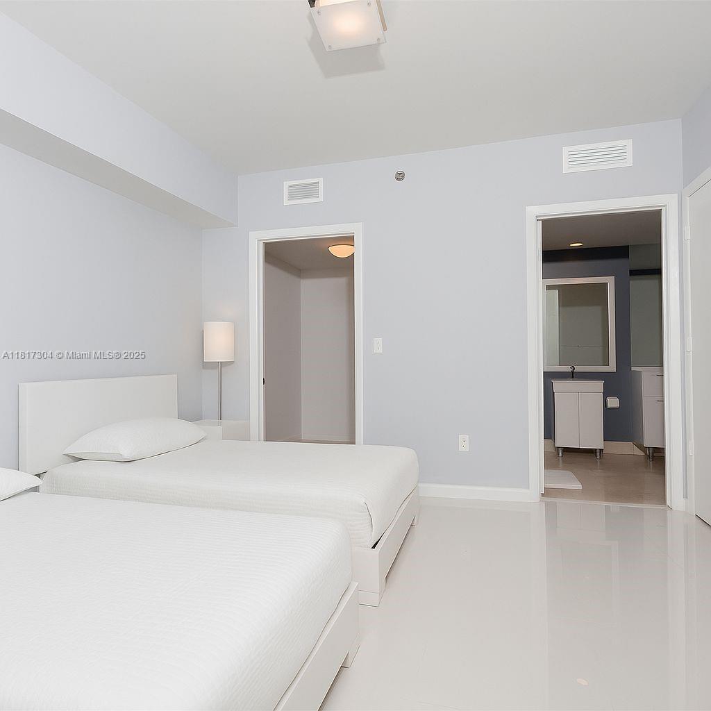 495 Brickell Avenue, Unit 5104 Miami, FL 33131 - Photo 14 of 21 a bedroom with a bed and a lamp
