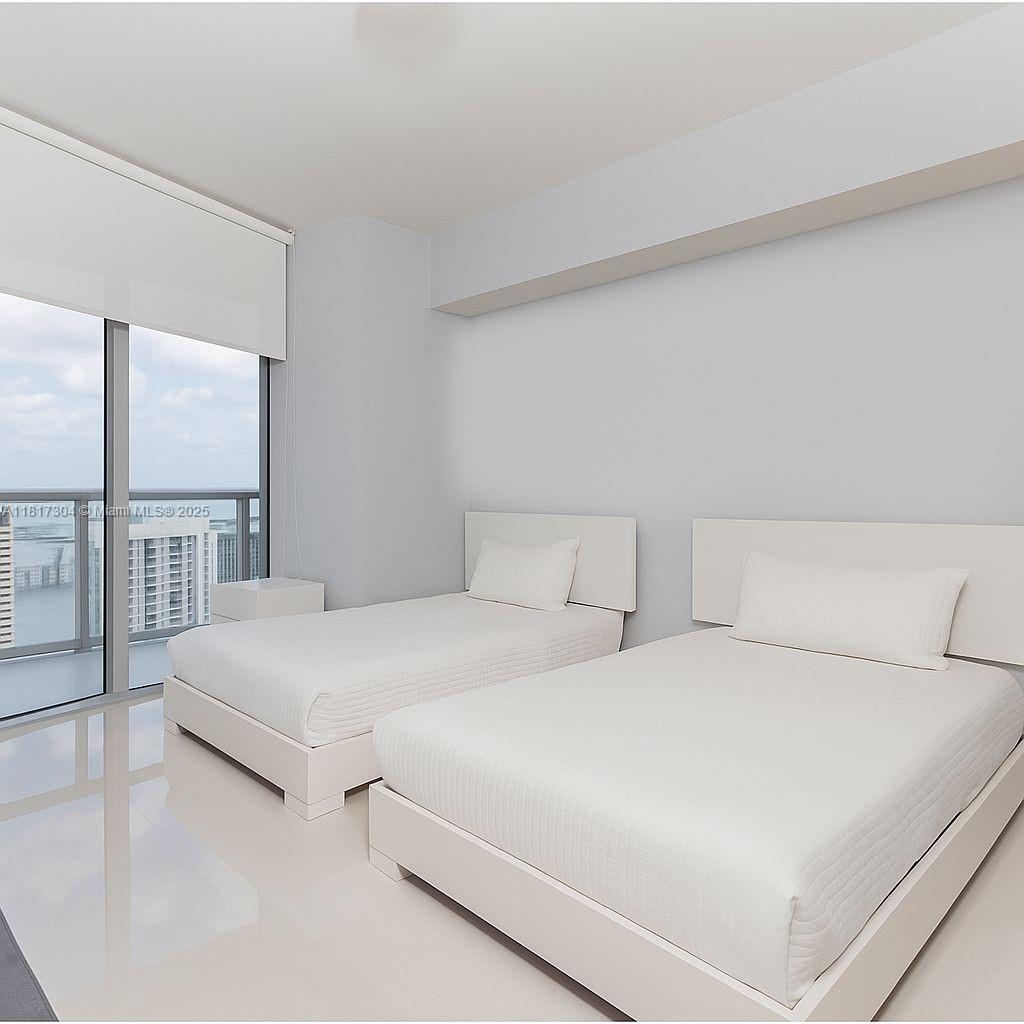 495 Brickell Avenue, Unit 5104 Miami, FL 33131 - Photo 15 of 21 a bedroom with two large bed and a large window