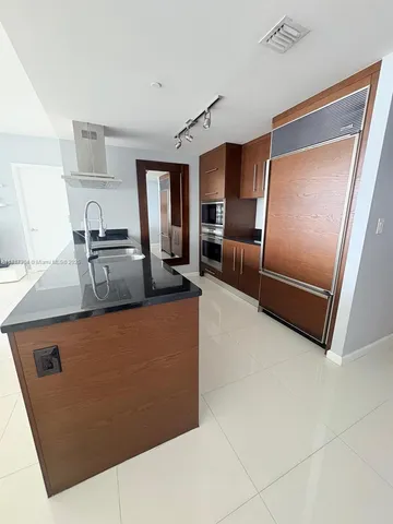 a kitchen with stainless steel appliances granite countertop a refrigerator and a stove