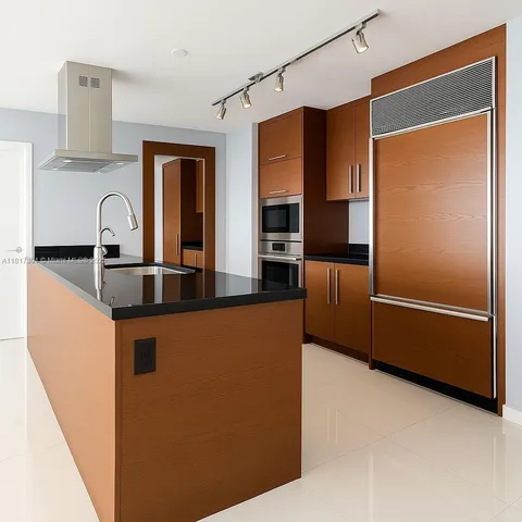 a kitchen with stainless steel appliances granite countertop a refrigerator and a sink
