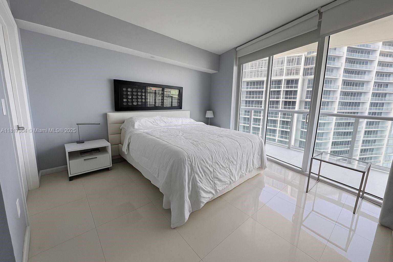 495 Brickell Avenue, Unit 5104 Miami, FL 33131 - Photo 9 of 21 a bedroom with a bed couch and a window