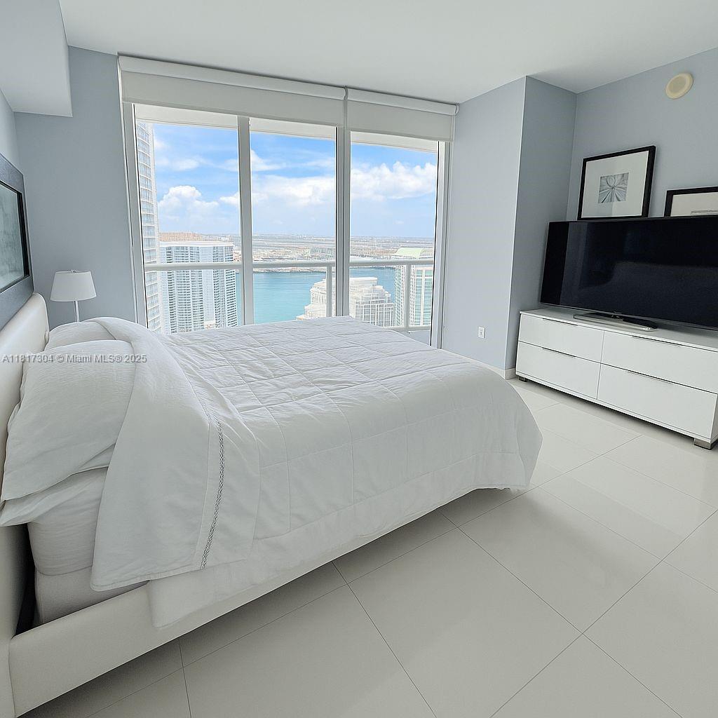 495 Brickell Avenue, Unit 5104 Miami, FL 33131 - Photo 10 of 21 a bedroom with a bed and a window