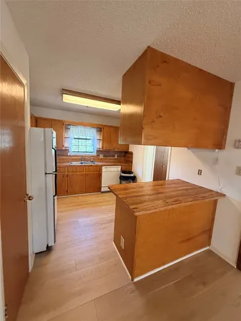 a kitchen with granite countertop a sink cabinets stainless steel appliances and a large window