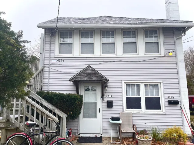 a view of a house with a door and a tree