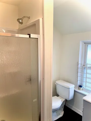 a white toilet sitting next to a bathroom sink and vanity