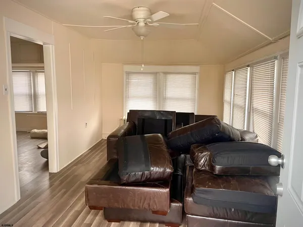 a living room with couches chairs and a coffee table with wooden floor
