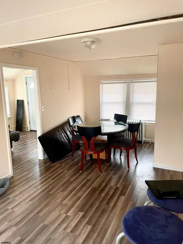 a living room with couches chairs and a coffee table with wooden floor