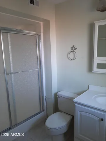 a white toilet sitting next to a shower in a bathroom