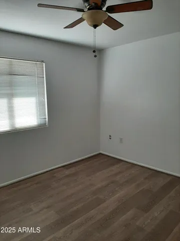 an empty room with a window and a fan