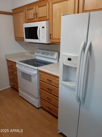 a kitchen with stainless steel appliances white cabinets and a refrigerator