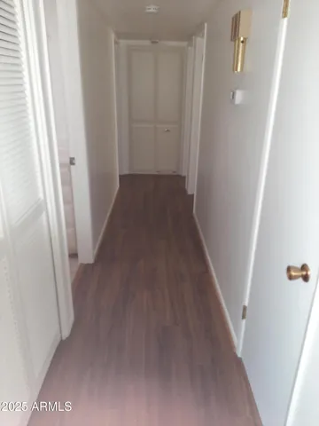 a view of a hallway with wooden floor